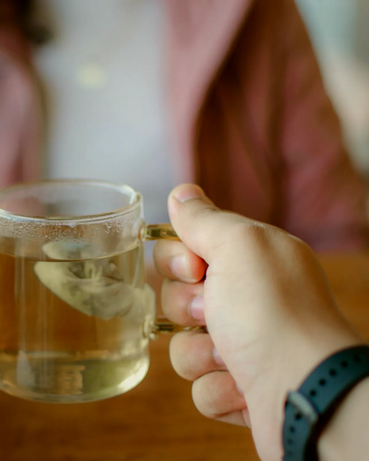 A teapot and cups set down beside a table mid-evening.